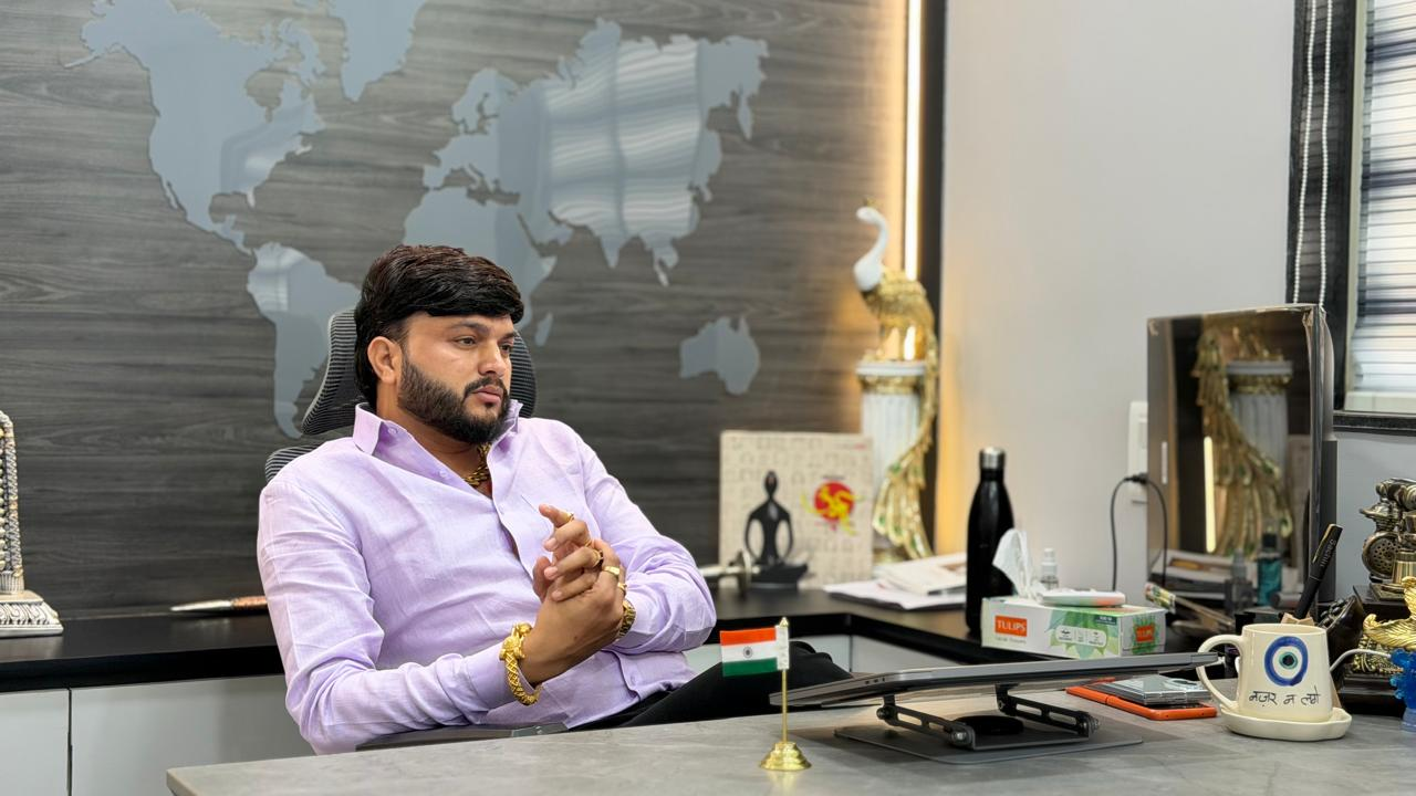 Maaax leader in conversation at his office desk